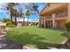 Large backyard with green grass and two-story home with a large upstairs balcony at 5225 Sandy Cactus Ln, Las Vegas, NV 89149