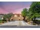 Stunning home featuring manicured landscaping, a spacious driveway, and a three-car garage against a beautiful twilight sky at 5225 Sandy Cactus Ln, Las Vegas, NV 89149