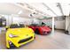 Spacious garage with two sports cars, custom cabinets, and epoxy floors at 5225 Sandy Cactus Ln, Las Vegas, NV 89149