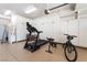 Spacious garage featuring ample storage cabinets and fitness equipment, including a treadmill and bicycle at 5225 Sandy Cactus Ln, Las Vegas, NV 89149