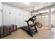 Organized garage featuring a treadmill, bicycle, storage cabinets, and luggage, maximizing space at 5225 Sandy Cactus Ln, Las Vegas, NV 89149
