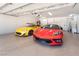 Bright garage with epoxy flooring and two sports cars, a yellow coupe and a red convertible at 5225 Sandy Cactus Ln, Las Vegas, NV 89149