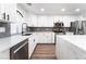Modern kitchen with white cabinetry, gray backsplash, stainless steel appliances, and quartz countertops at 5225 Sandy Cactus Ln, Las Vegas, NV 89149