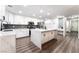 Beautiful kitchen with white cabinetry, gray backsplash, stainless steel appliances, and a large center island with quartz countertops at 5225 Sandy Cactus Ln, Las Vegas, NV 89149