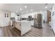 Bright kitchen boasts white cabinets, stainless steel appliances, large island with marble countertop, and gray backsplash at 5225 Sandy Cactus Ln, Las Vegas, NV 89149
