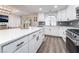 Open kitchen with white cabinets, stainless steel appliances, gray backsplash, and a large island with quartz countertop at 5225 Sandy Cactus Ln, Las Vegas, NV 89149
