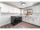 Bright laundry room with washer, dryer, sink, white cabinetry, and wood-look floors at 5225 Sandy Cactus Ln, Las Vegas, NV 89149