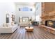 Bright living room featuring a stone fireplace, piano, and large windows at 5225 Sandy Cactus Ln, Las Vegas, NV 89149