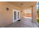 Covered patio with double doors, tile flooring, and decorative wall-mounted sconces at 5225 Sandy Cactus Ln, Las Vegas, NV 89149
