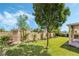 Large backyard featuring green grass, trees, a rock bed and a covered patio at 532 Kavanagh Pl, Las Vegas, NV 89123