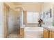 Well-lit bathroom featuring a bathtub, shower with glass door, and window at 532 Kavanagh Pl, Las Vegas, NV 89123