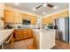 Well-lit kitchen features wood cabinets, stainless steel refrigerator, kitchen island and hardwood floors at 532 Kavanagh Pl, Las Vegas, NV 89123