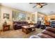 Comfortable living room featuring large windows, dark leather seating and neutral decor at 532 Kavanagh Pl, Las Vegas, NV 89123