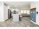 Modern kitchen boasts white cabinetry, stainless steel appliances, and an island with barstools at 551 Swiss Cottage Ave, Las Vegas, NV 89178