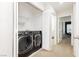 Laundry area featuring a new front-load washer and dryer and door to the hallway at 551 Swiss Cottage Ave, Las Vegas, NV 89178