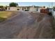 A single story home with a dirt driveway, a well-manicured lawn, and a brown wooden fence at 5617 Alfred Dr, Las Vegas, NV 89108