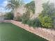Backyard with artificial turf and a landscaped retaining wall at 6043 Cape Clairmont Ct, North Las Vegas, NV 89031