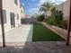 A well-maintained backyard with artificial grass, a patio, and landscaped wall at 6043 Cape Clairmont Ct, North Las Vegas, NV 89031