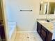 Bathroom with single vanity, granite countertops, bathtub, and tile floors at 6043 Cape Clairmont Ct, North Las Vegas, NV 89031