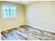 A bedroom with wood-look flooring, clean walls, and a window providing natural light at 6043 Cape Clairmont Ct, North Las Vegas, NV 89031
