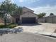 Inviting home featuring a two-car garage, low-maintenance landscaping, and a spacious driveway for additional parking at 6043 Cape Clairmont Ct, North Las Vegas, NV 89031