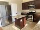 The kitchen has stainless steel appliances, granite countertops, a kitchen island, and tile flooring at 6043 Cape Clairmont Ct, North Las Vegas, NV 89031