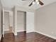 Neutral secondary bedroom featuring hardwood floors, fan, and sliding closet at 612 Moontide Ct, Henderson, NV 89011