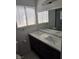 Modern bathroom featuring double sinks with dark cabinets and a large mirror at 6402 Agua Dr, Las Vegas, NV 89103
