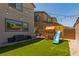 Inviting backyard with artificial grass, a playset, and charming string lights at 6927 Desert Finch St, North Las Vegas, NV 89084