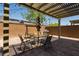 Backyard featuring a pergola, outdoor dining set, swing, grill, and artificial grass at 6927 Desert Finch St, North Las Vegas, NV 89084