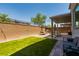 Backyard with artificial grass, paver patio, a pergola with string lights, and a swing at 6927 Desert Finch St, North Las Vegas, NV 89084