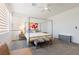 Bright bedroom featuring a four-poster bed, soft gray carpet, and neutral-toned walls at 6927 Desert Finch St, North Las Vegas, NV 89084