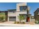 Modern two-story home featuring a gray garage door, orange front door, and stylish stone accents at 6927 Desert Finch St, North Las Vegas, NV 89084