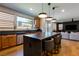 A modern kitchen and living room combo with sleek appliances and an expansive island with counter seating at 6927 Desert Finch St, North Las Vegas, NV 89084