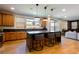 Stylish kitchen with wooden cabinets, a center island with bar stools, and modern lighting fixtures at 6927 Desert Finch St, North Las Vegas, NV 89084