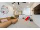 Open living room with a comfortable sofa, ' toys, and natural light at 6927 Desert Finch St, North Las Vegas, NV 89084