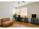 Bright home office with ample natural light, a modern desk setup, and a cozy leather couch at 6927 Desert Finch St, North Las Vegas, NV 89084