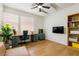 Bright home office with ample natural light, a modern desk setup, and a cozy leather couch at 6927 Desert Finch St, North Las Vegas, NV 89084