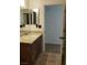 Neat bathroom featuring a dark vanity with granite countertops, a sink, and tiled floors at 728 Apple Tree Ct, Henderson, NV 89014