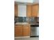 Kitchen with wood cabinets, tile backsplash, stone countertops, and stainless steel dishwasher at 728 Apple Tree Ct, Henderson, NV 89014