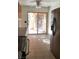 Open kitchen with stainless steel refrigerator and tile floors with door leading to the backyard at 728 Apple Tree Ct, Henderson, NV 89014