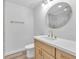 This bathroom offers stylish finishes, including a modern round mirror, a light wood vanity, and sleek gold fixtures at 747 Greenbriar Townhouse Way, Las Vegas, NV 89121