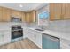 Bright kitchen with wood cabinets, stainless appliances, and a large window over the sink at 747 Greenbriar Townhouse Way, Las Vegas, NV 89121