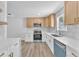 Bright kitchen boasts stainless appliances, tile backsplash, wooden cabinets and plank flooring at 747 Greenbriar Townhouse Way, Las Vegas, NV 89121