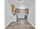 Modern kitchen featuring stainless steel appliances, white cabinets, and light wood flooring at 747 Greenbriar Townhouse Way, Las Vegas, NV 89121