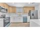 Modern kitchen featuring stainless steel appliances, white cabinets, and light wood flooring at 747 Greenbriar Townhouse Way, Las Vegas, NV 89121