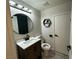 Well lit bathroom with modern vanity, round mirror, and gray plank flooring at 7537 Brisa Del Mar Ave, Las Vegas, NV 89179