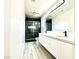 Modern bathroom featuring dual sinks, sleek black fixtures, and a glass-enclosed shower at 7537 Brisa Del Mar Ave, Las Vegas, NV 89179
