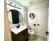 Modern bathroom featuring a round mirror, hexagon storage shelf, updated vanity and fixtures, with a toilet at 7537 Brisa Del Mar Ave, Las Vegas, NV 89179