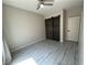 Bright bedroom with sliding barn doors, modern ceiling fan and light gray plank flooring at 7537 Brisa Del Mar Ave, Las Vegas, NV 89179
